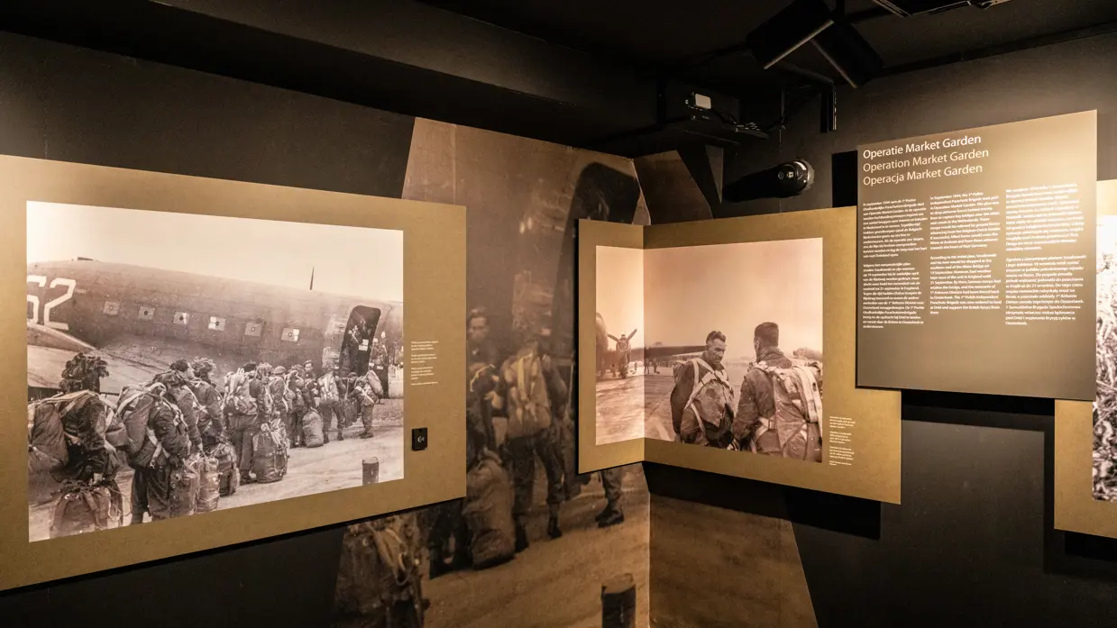 Twee zwart-wit foto’s op de expositie. Op de ene staan mannen die een vliegtuig in lopen, de ander vertoont Stasinek met parachutistentuig. Daarnaast is een plaquette te zien met uitleg over de Operatie Market Garden.