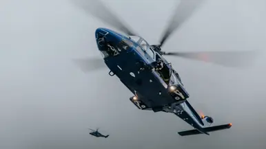 Alt: Op de linkerfoto klimt een militair aan boord, terwijl een collega dekking geeft. Rechts hangt een blauwe politiehelikopter stil boven het schip om operators af te zetten aan boord. 