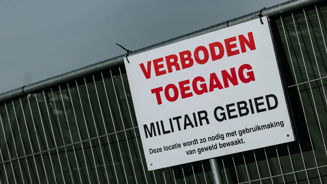Een wit bord met de tekst: verboden toegang, militair geweld.  