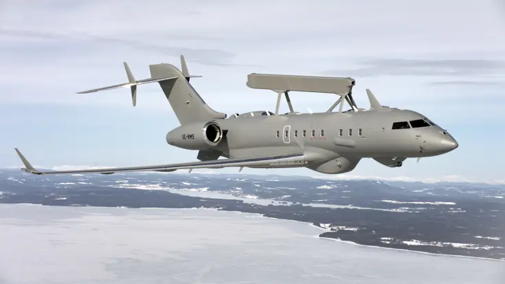 Een grijze GlobalEye vliegt boven een besneeuwde omgeving.