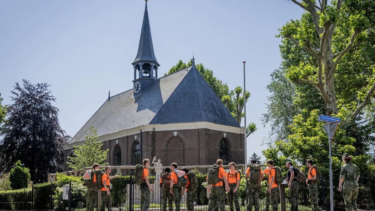 Studenten staan bij het monument te kijken