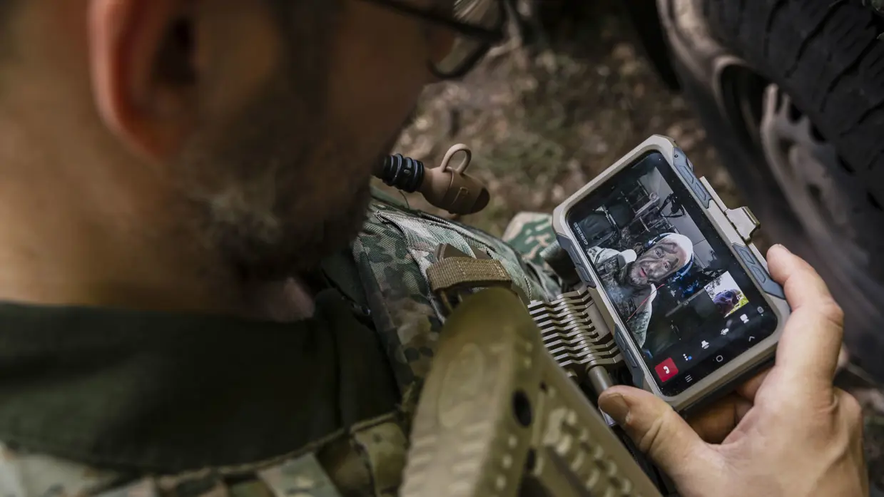 Een militair te velde met een mobiel device.
