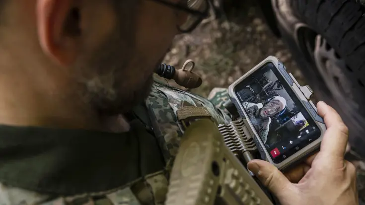 Een militair te velde met een mobiel device.