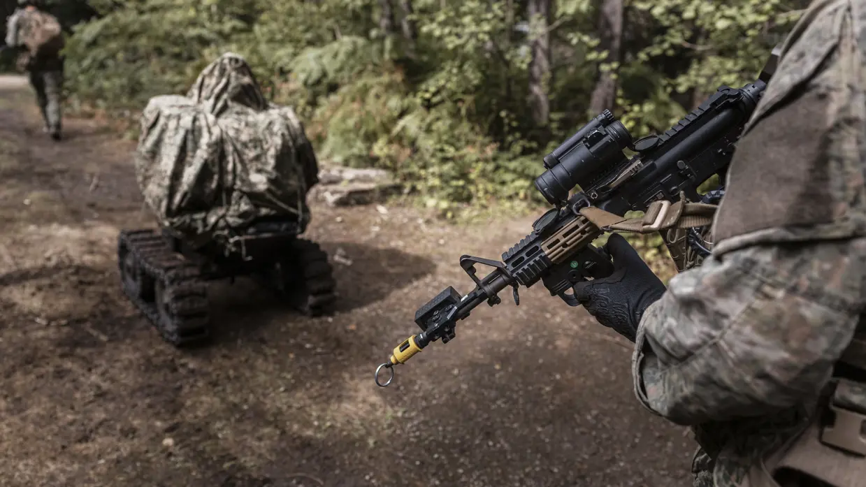 Een militair heeft een afstandsbediening aan z’n pistoolgrip om de Wild Goose te besturen.