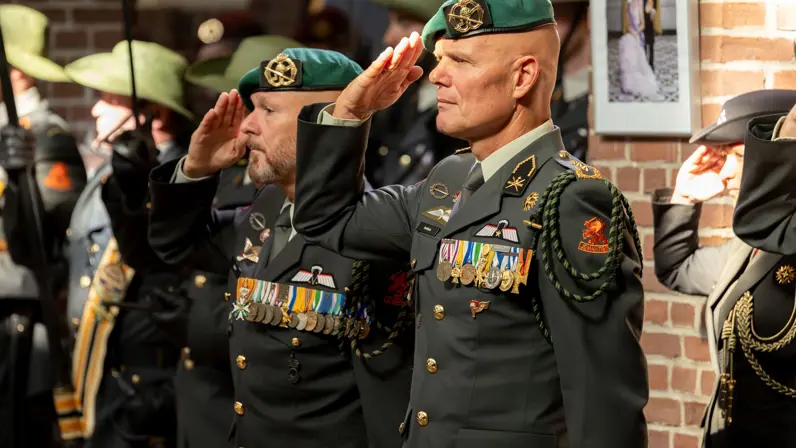 Twee officieren van de landmacht, beiden zwaar gedecoreerd, brengen de eregroet.