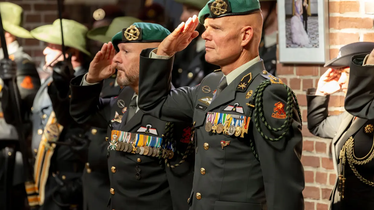 Twee officieren van de landmacht, beiden zwaar gedecoreerd, brengen de eregroet.