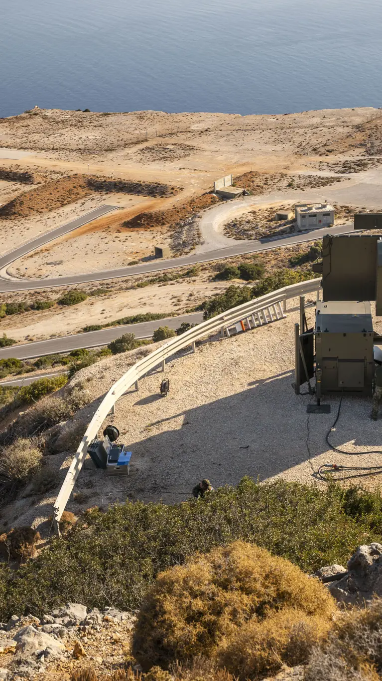Overzichtsfoto van het schietterrein op Kreta. Rechts staat de Groundmaster 400 opgesteld, links diverse schietpunten met daarachter de zee.