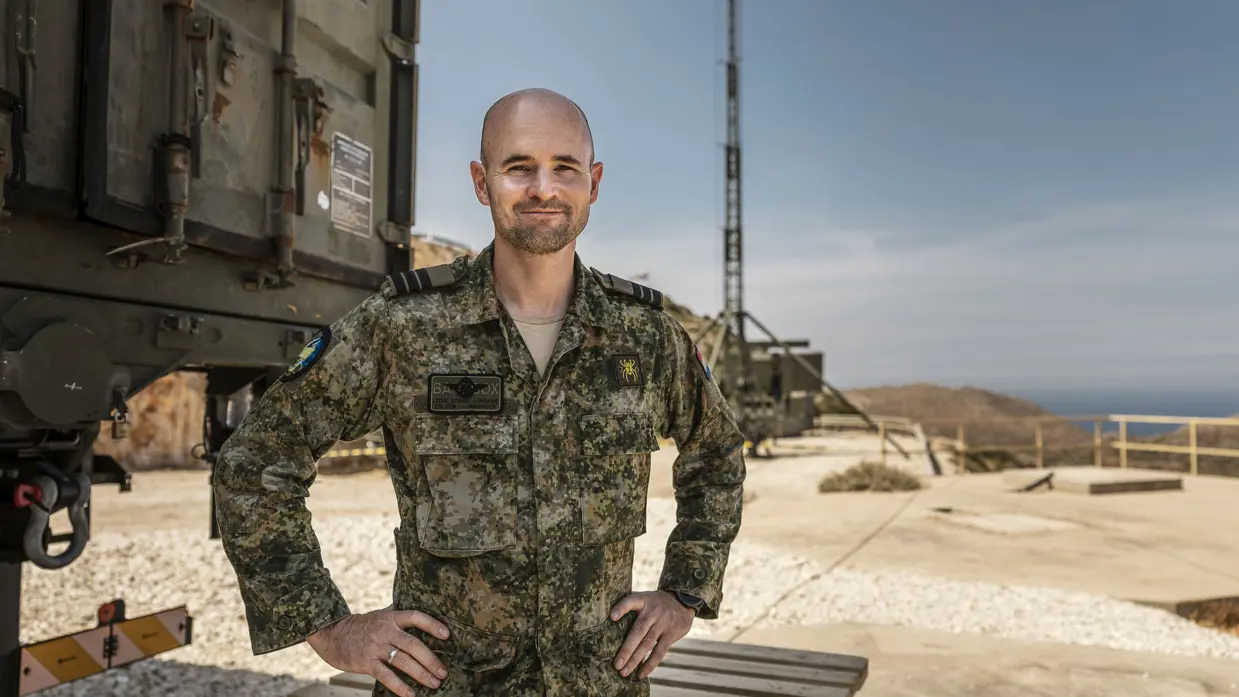 Portretfoto van commandant Stuart Lorraine met een antennemast in de achtergrond.