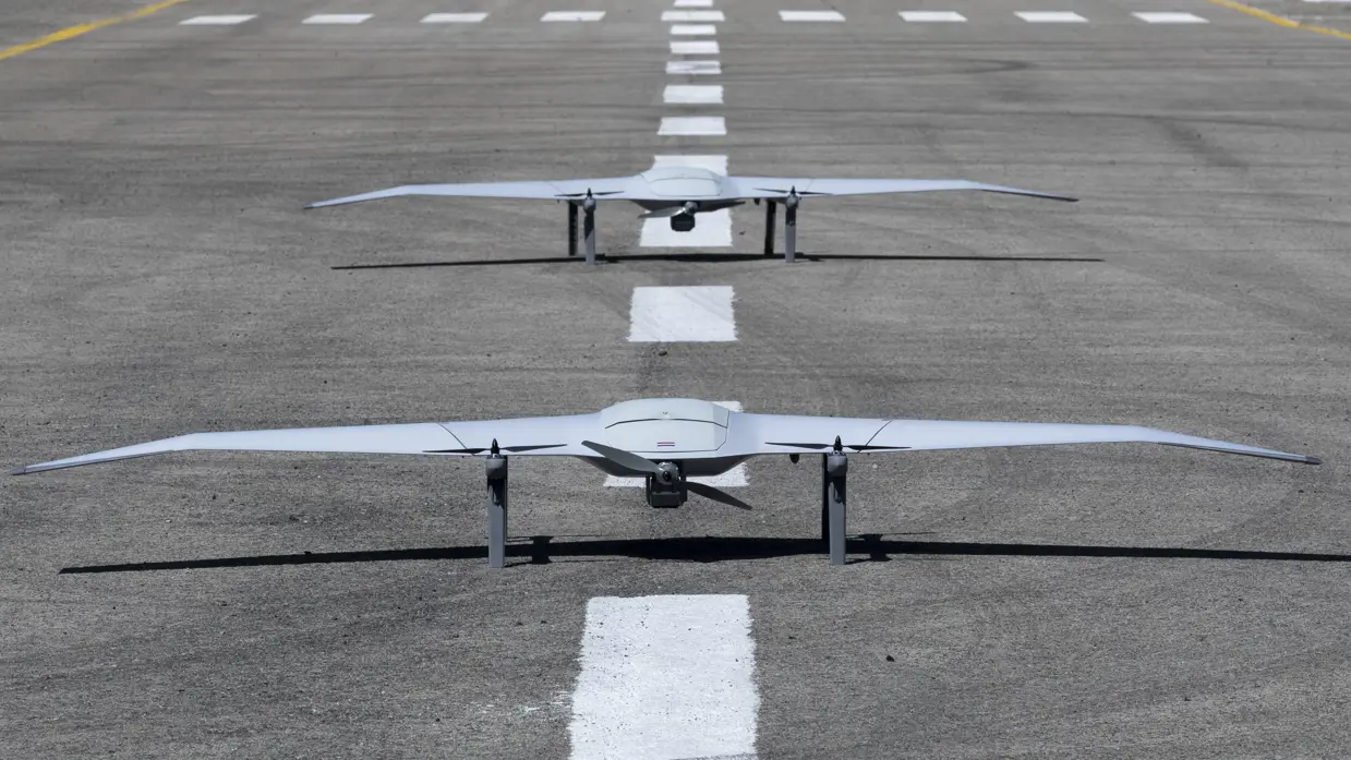  2 drones staan achter elkaar op een landingsbaan.