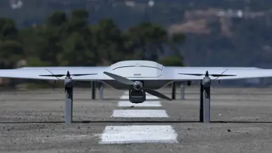 Een grijze drone met daarop een Nederlands vlaggetje op een start- en landingsbaan. 