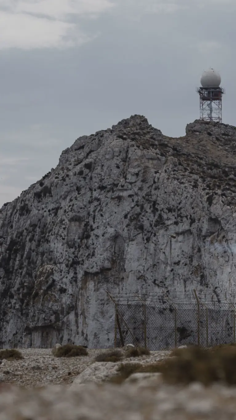 Militairen in een zogeheten ghillie suit (bijzonder soort camouflagepak) schieten een Stinger-luchtdoelraket in een landschap vol rotsen.