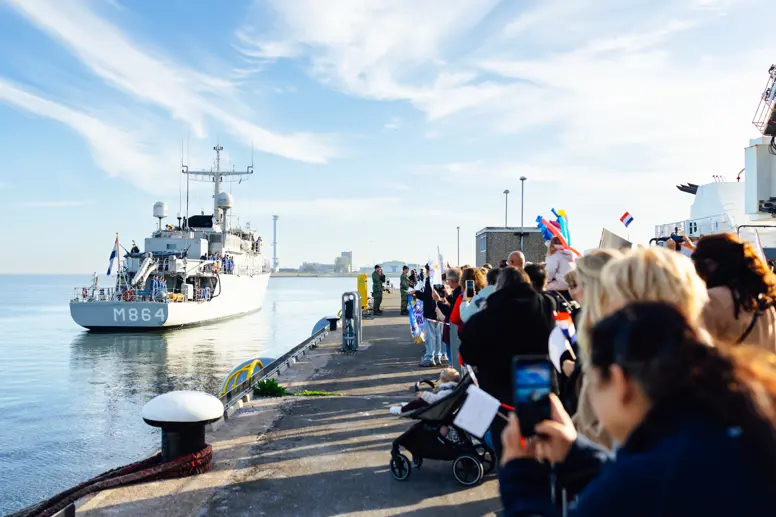 Een schip komt aan in de haven.