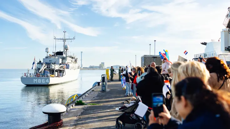 Een schip komt aan in de haven.