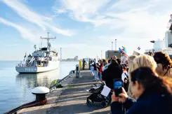 Een schip komt aan in de haven.
