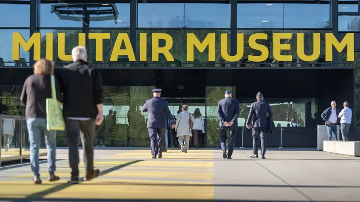 Militairen lopen naar de ingang van het NMM.