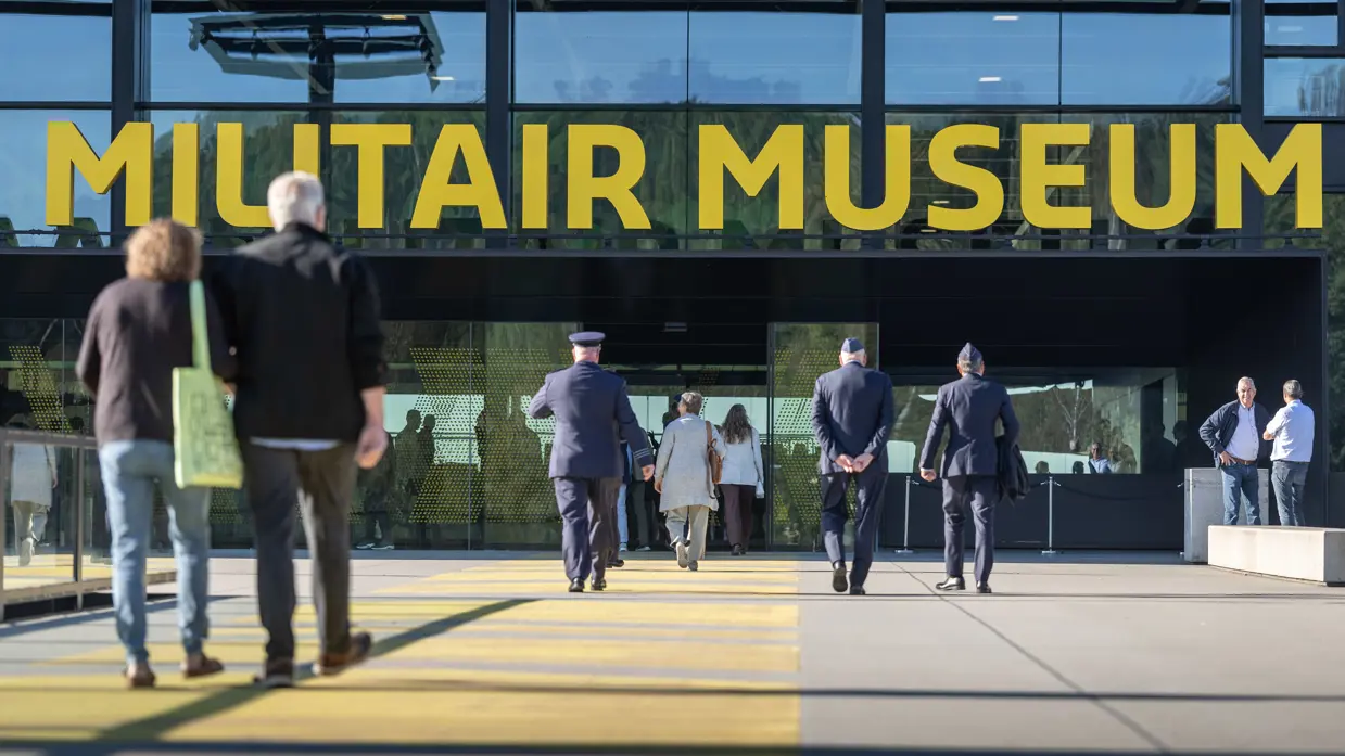 Militairen lopen naar de ingang van het NMM.