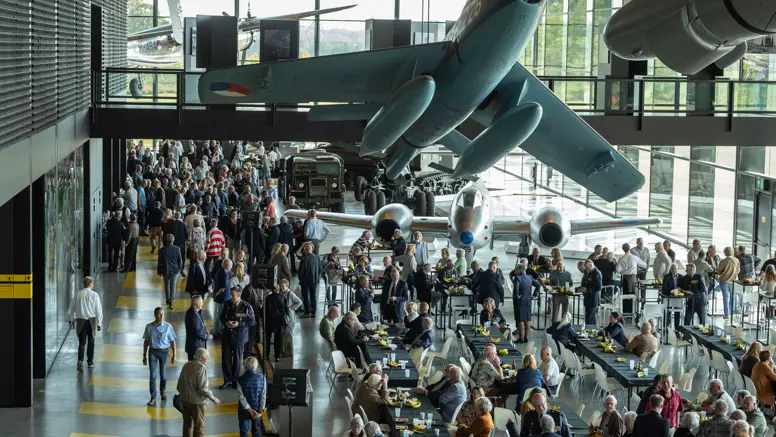 Foto van bovenaf, grote groepen mensen lopen door het museum.