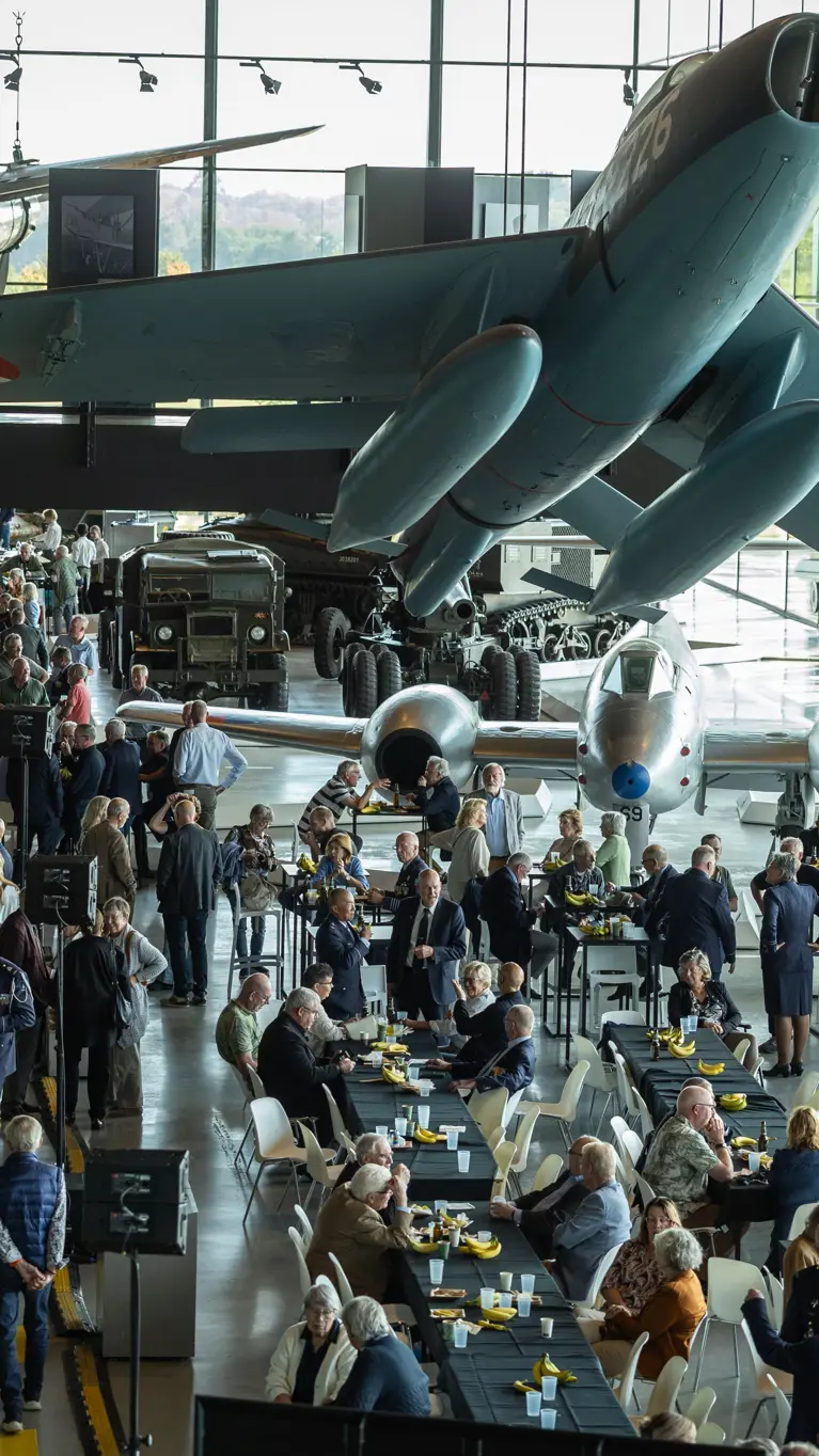 Foto van bovenaf, grote groepen mensen lopen door het museum.