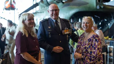 Peter Massop poseert lachend met twee vrouwen.