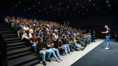 Gelf de Jong op het podium voor een zaal studenten