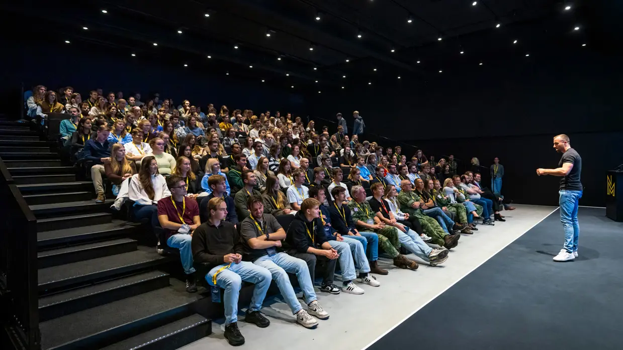 Gelf de Jong op het podium voor een zaal studenten