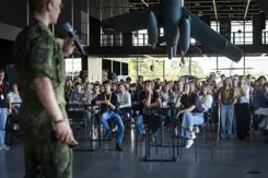 Stagiairs luisteren naar een man die hen toespreekt.