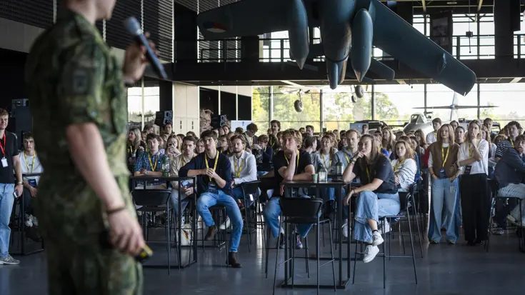Stagiairs luisteren naar een man die hen toespreekt.