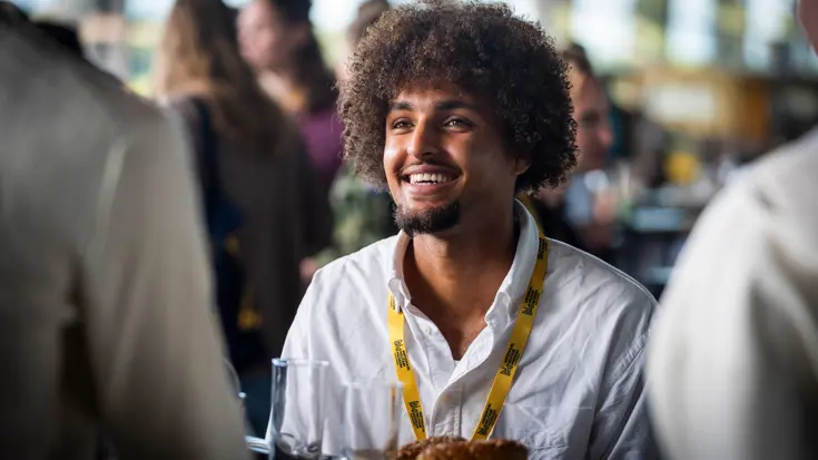 Deion lachend aan een tafel 