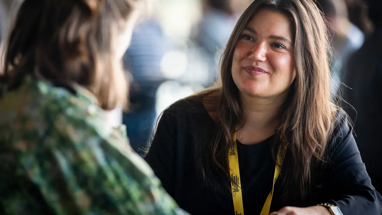 Tessa aan een tafel in gesprek