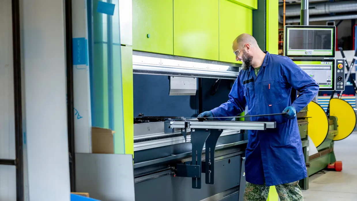 Erik bedient een industriële kantoormachine/kantbank.