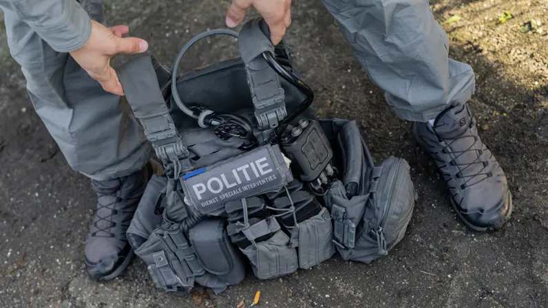 Vest van de DSI wordt door twee handen omhoog getild.