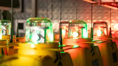 Gele units met een lamp erop, achter elkaar opgelijnd in de wagen tegen een grijze achtergrond. De lampen staan aan.