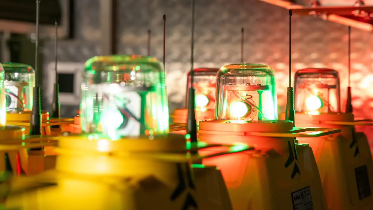 Gele units met een lamp erop, achter elkaar opgelijnd in de wagen tegen een grijze achtergrond. De lampen staan aan.