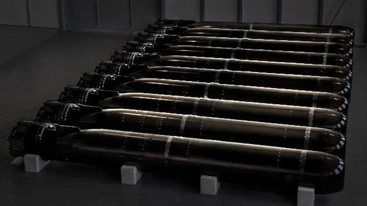 Een rijtje torpedo’s liggend in een bak.