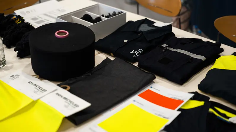 Voorbeelden van innovatieve toepassingen in de circulaire textielketen: van zwarte garen en grondstoffen tot gerecyclede kledingstukken en stofstalen die getuigen van de nieuwe duurzaamheidseisen