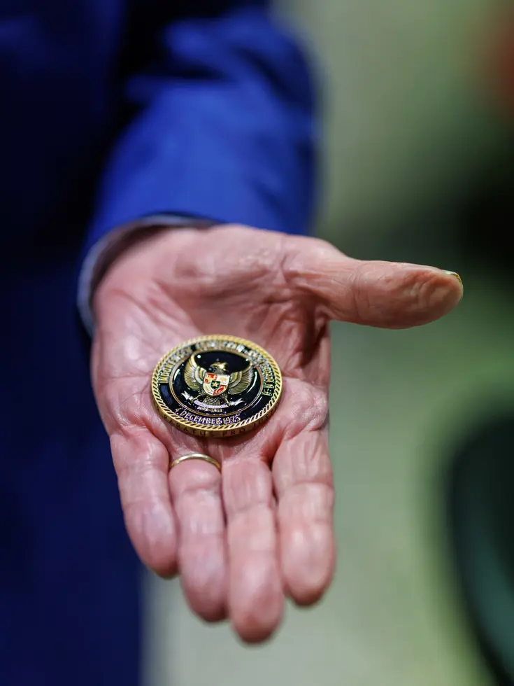 Een zwart-gouden munt in de palm van een hand. 