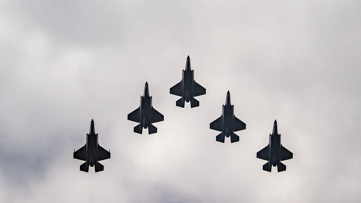 5 F-35 gevechtsvliegtuigen vliegen over.
