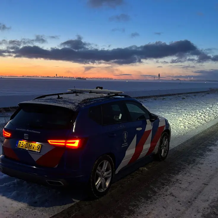 Voertuig van de Marechaussee voor besneeuwd Schiphol.