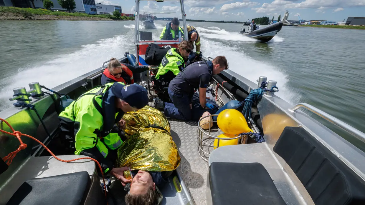 Slachtoffers worden in een boot geholpen door marachaussees