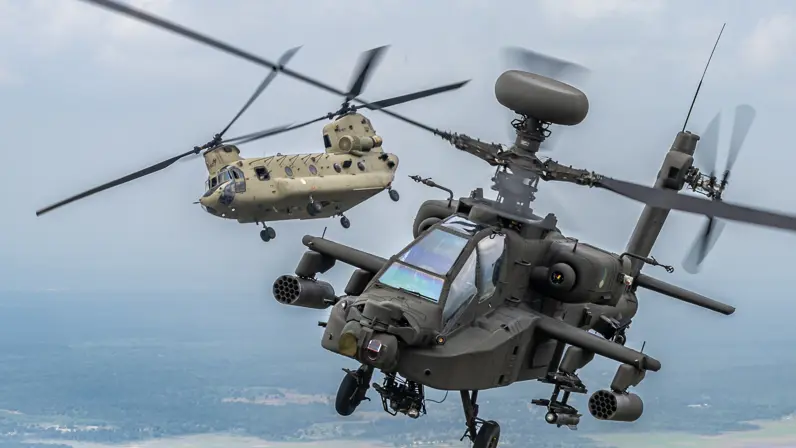 Een Apache Echo. Met radarbol bovenop, vliegt iets voor een Chinook transporthelikopter.