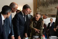Drie politici in gesprek met militairen.