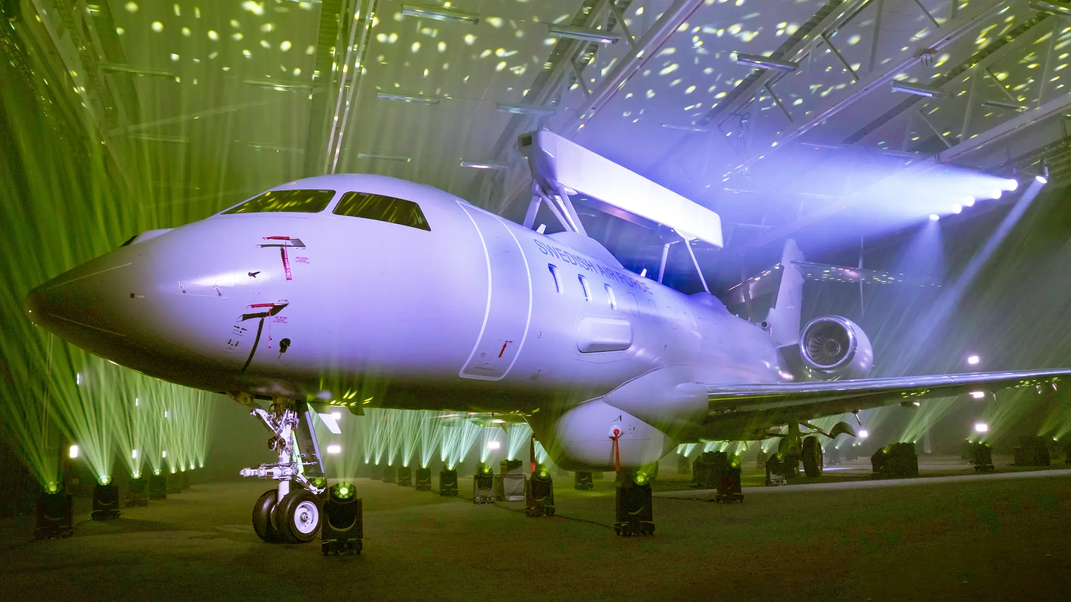 Onthulling van een Zweedse Saab GlobalEye in een hangar met veel gekleurde lampen 