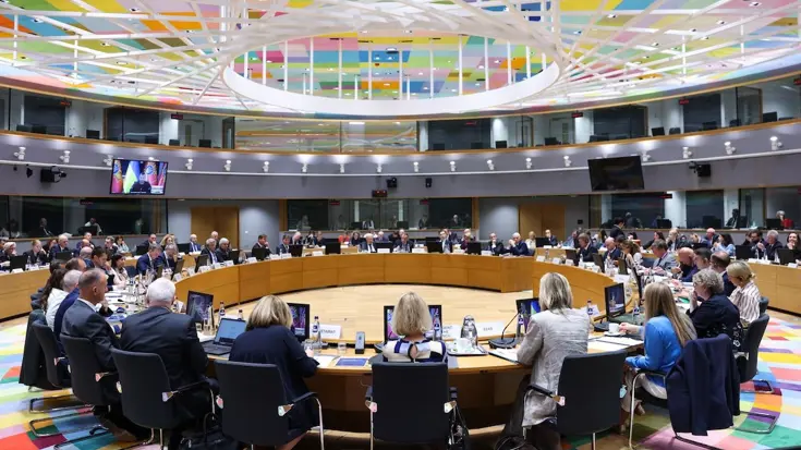  Europese defensieministers zitten aan een ronde tafel. 