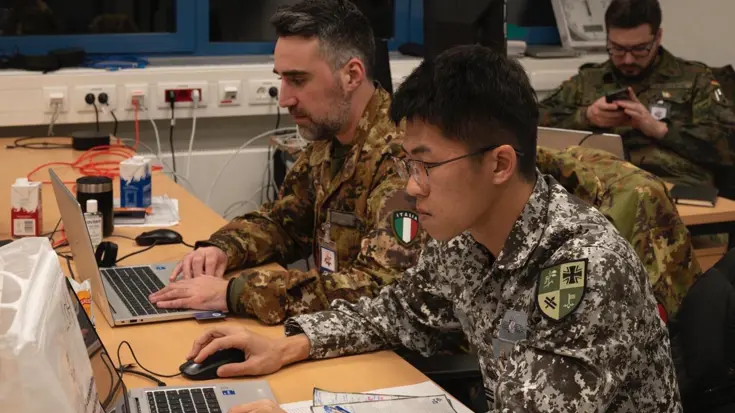 Twee militairen achter een laptop.
