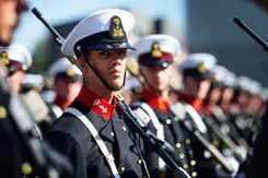 Rij adelborsten in ceremonieel tenue kijkt naar links.