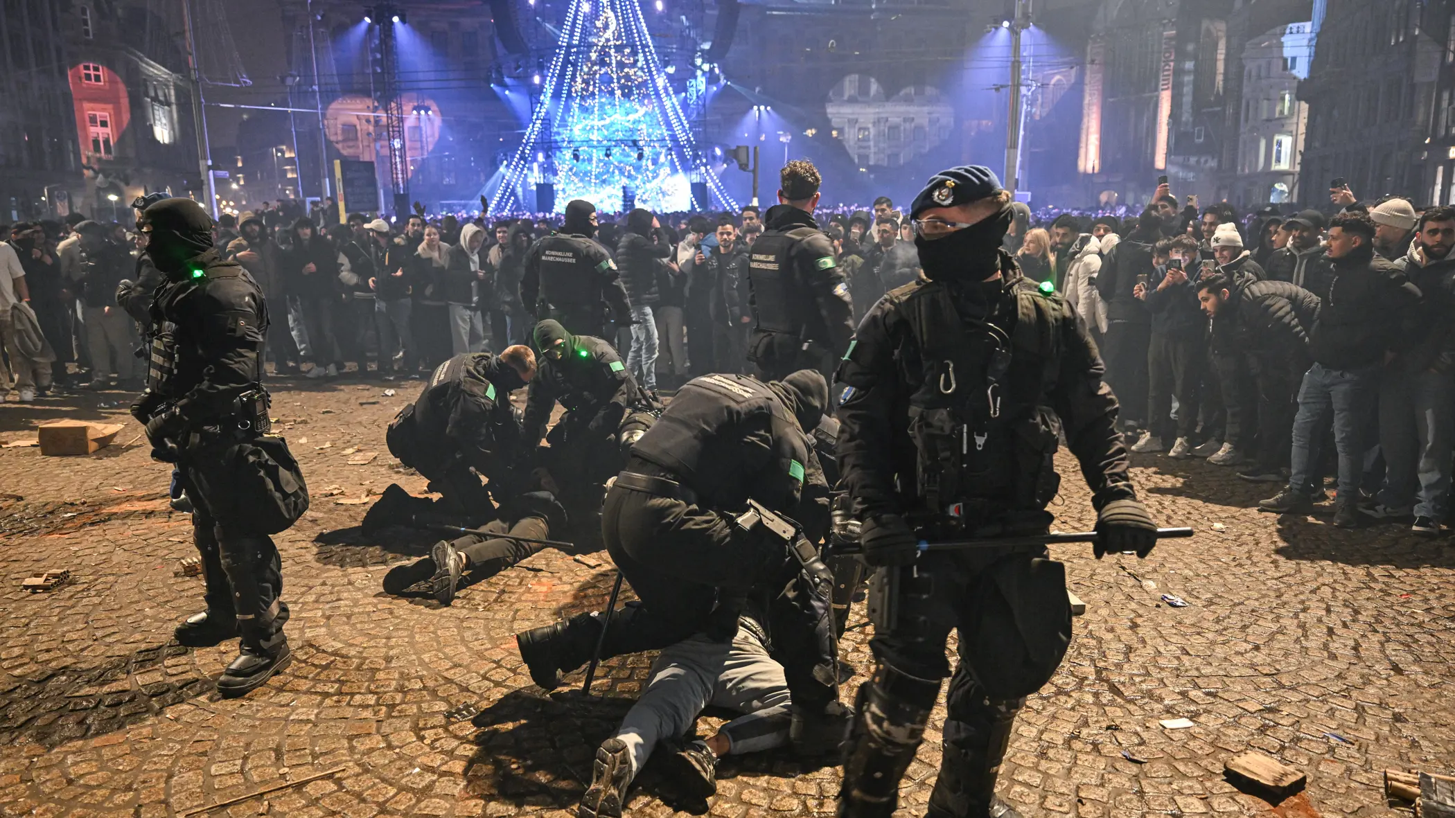 Voertuigen van de ME en politie met mannen met schilden ervoor.