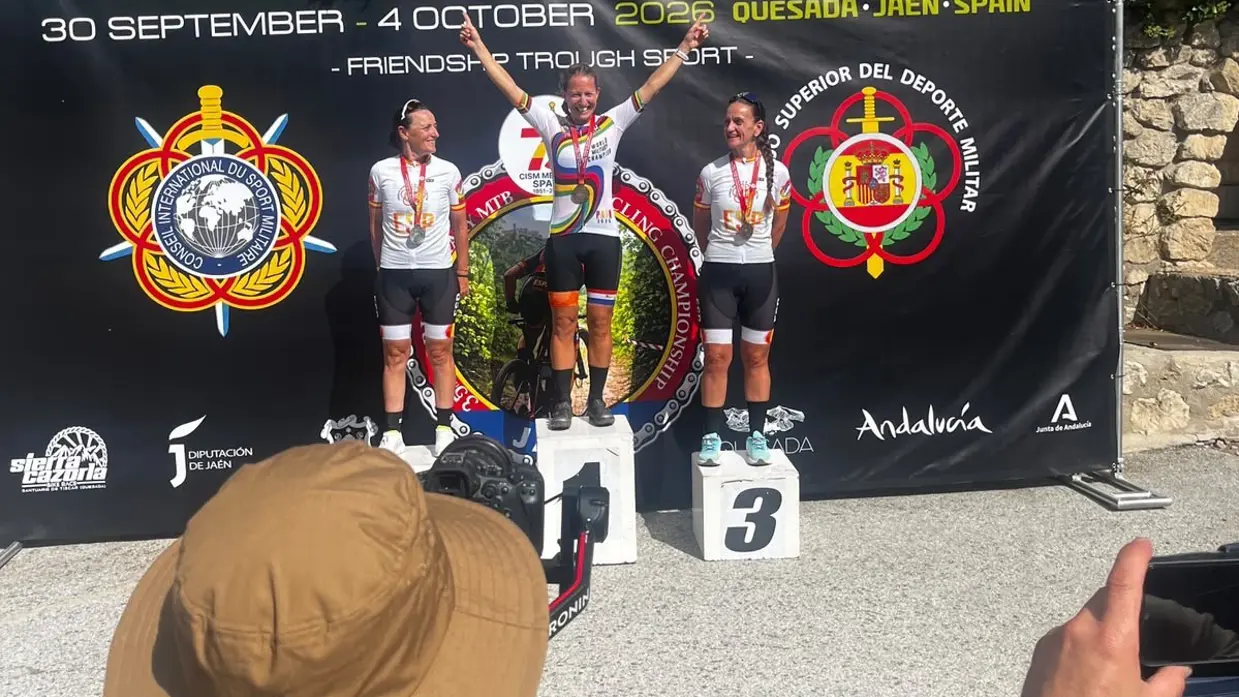 Militairen in fietskleding op podium tijdens medaille-uitreiking.