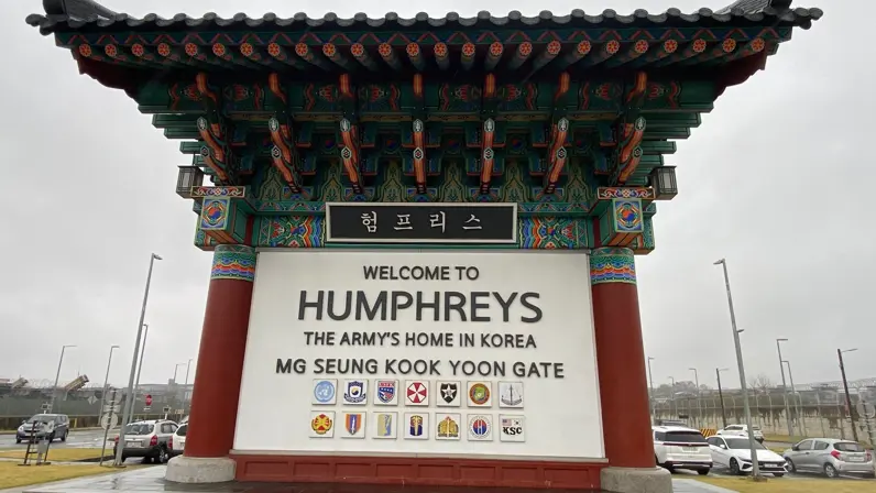 Een groot bord met daarop de tekst: Welkom op Humphreys. Het huis van de landmacht in Korea. Erboven staan Koreaanse tekens. 