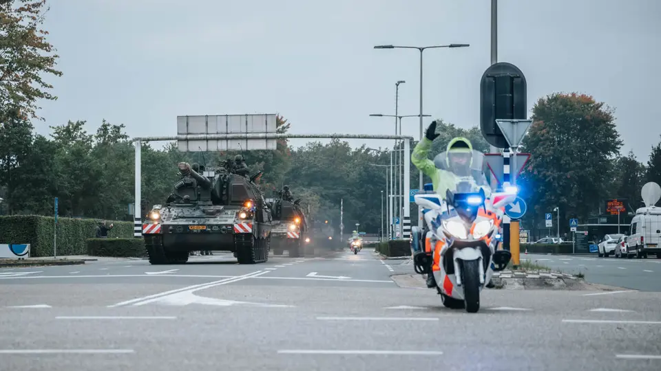 Een motor van de Marechaussee met op de achtergrond voertuigen van de Landmacht.
