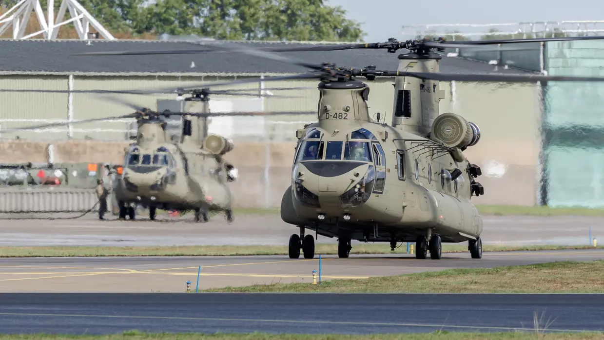 Een militaire helikopter staat stil op een landings- en vertrekbaan.